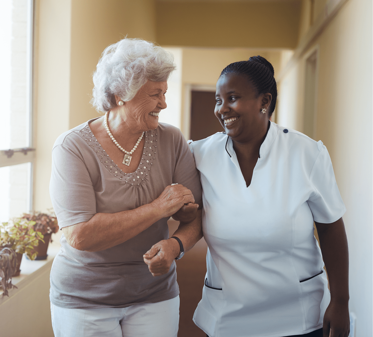 Elderly woman and caregiver smiling together
