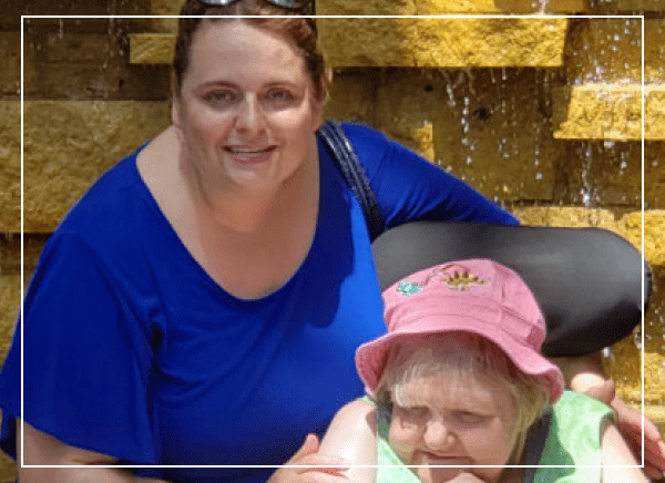 Two women smiling near a fountain