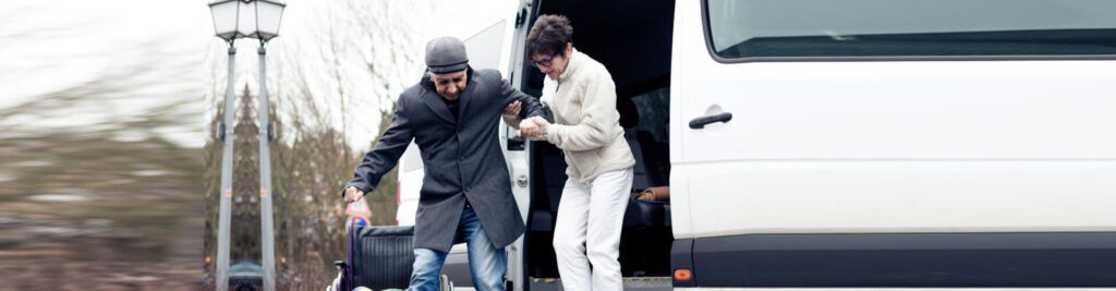 Man assisting another out of van