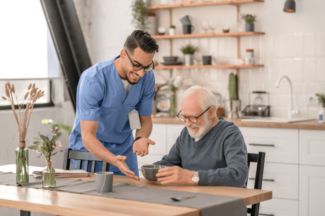 Healthcare worker and senior enjoying tea together