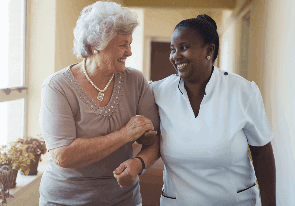 Elderly woman and caregiver smiling together