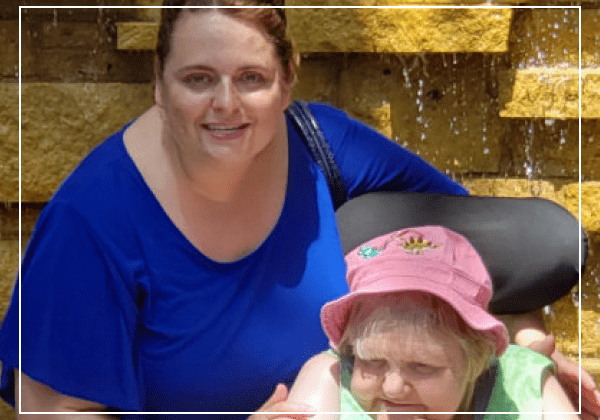 Two women smiling near a fountain