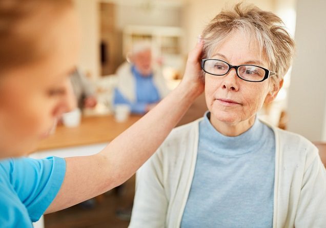 Healthcare worker comforting elderly woman