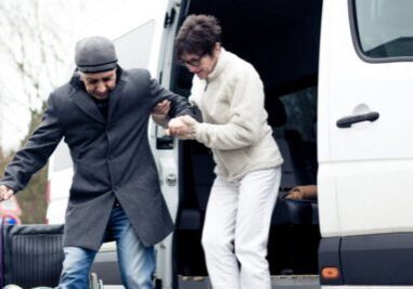 Man assisting another out of van