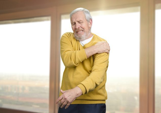 Man clutching sore shoulder in pain